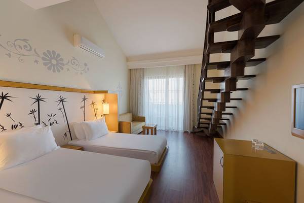Schlafzimmer im Siam Elegance Hotels & Spa mit zwei Betten, Klimaanlage und spiralförmiger Treppe.