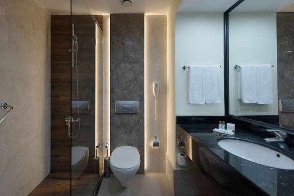 Ein modernes Badezimmer mit einer Dusche, Toilette, Waschbecken und Marmorboden im Siam Elegance Hotels & Spa.
