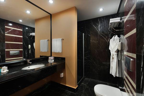 Badezimmer im Siam Elegance Hotels & Spa mit schwarzem Marmor und weißem Handtuchhalter.