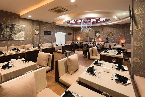 Innenbereich eines Restaurants im Siam Elegance Hotel mit Tisch und Stuhlarrangements.