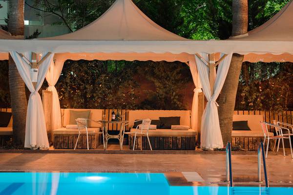 Außenbereich des Siam Elegance Hotels & Spa mit Pool, Loungemöbeln und Zelt
