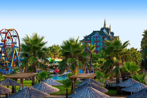 Außenbereich des Siam Elegance Hotels & Spa mit Fahrgeschäft, Pool und vielen Palmen