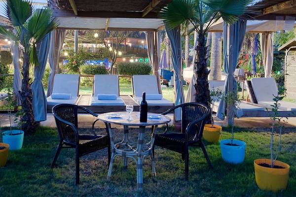 Außenbereich des Siam Elegance Hotels mit Lounge-Stühlen, Tischen und Pflanzen.