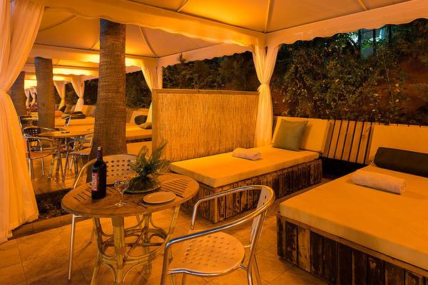 Lounge-Bereich im Siam Elegance Hotels & Spa mit Betten, Tischen und Pflanzen.