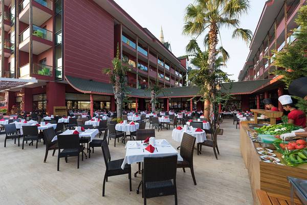 Außenbereich des Siam Elegance Hotels & Spa mit vielen gedeckten Tischen und aufgestelltem Buffet.