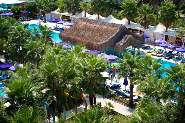 Luftaufnahme des Siam Elegance Hotels & Spa mit Pools, Liegestühlen und Sonnenschirmen.