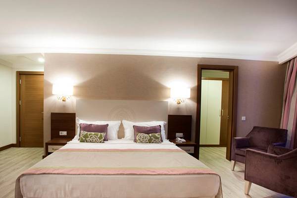 Schlafzimmer im Side Alegria Hotel & Spa mit großem Bett, Nachttischen und Sesseln.