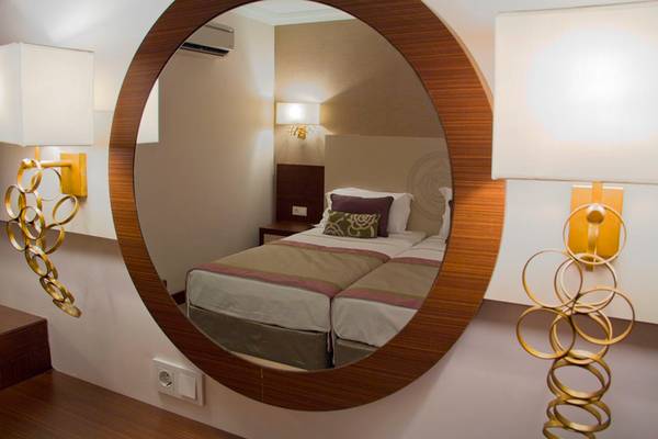 Spiegel mit Reflektion eines Doppelbettes im Zimmer des Side Alegria Hotel & Spa
