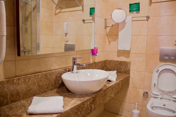 Badezimmer im Side Alegria Hotel & Spa mit Waschbecken, Spiegel, Toilette und Handtüchern.