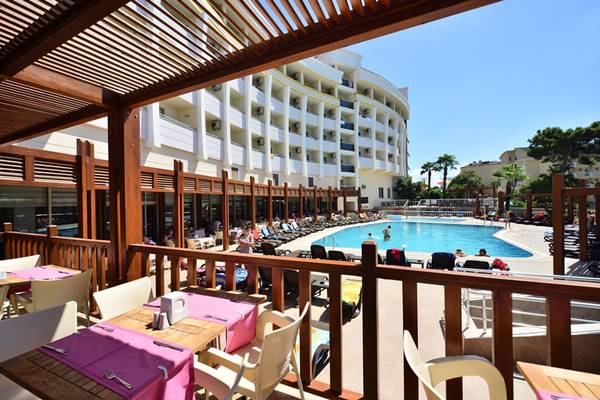 Außenansicht des Side Alegria Hotel & Spa mit Swimmingpool und Terrasse mit Tischen und Stühlen.