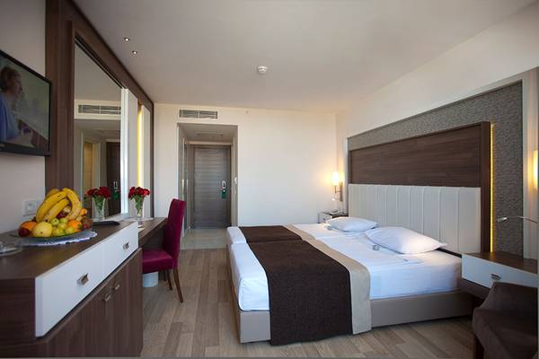 Doppelzimmer im Side Mare Resort & Spa mit zwei Betten, Schreibtisch und Früchten.