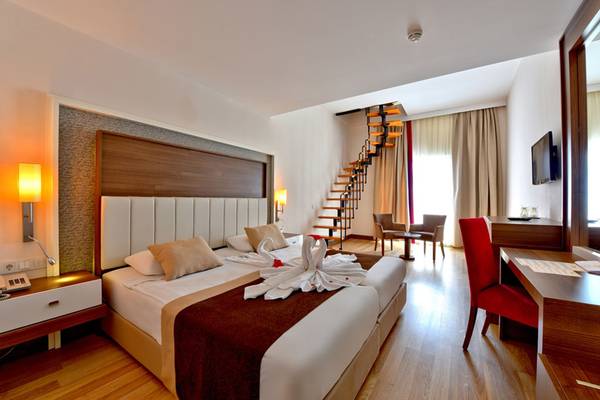 Hotelzimmer im Side Mare Resort & Spa mit zwei Betten, Stairs, Tisch und Fernseher.