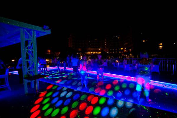 Nachtliche Laser-Party auf dem Hotel-Deck mit bunten Lichtern und tanzenden Gasten.