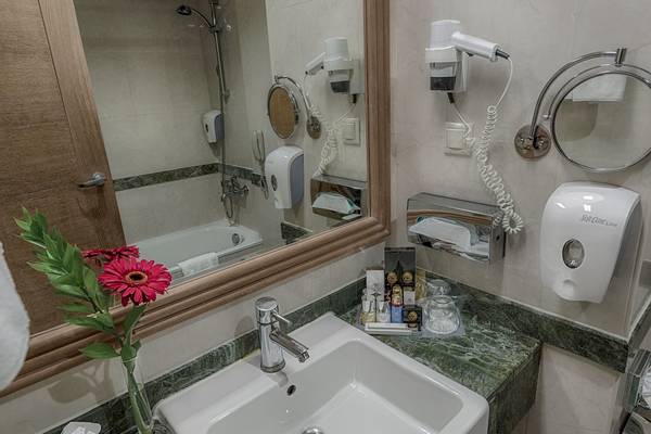 Badezimmer im Dobedan Beach Resort Comfort Hotel mit Waschbecken, Spiegel und Handtüchern.