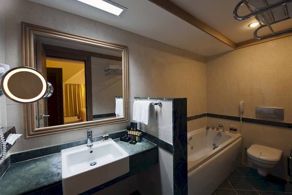 Badezimmer im Dobedan Beach Resort Comfort mit Waschbecken, Spiegel und Badewanne.