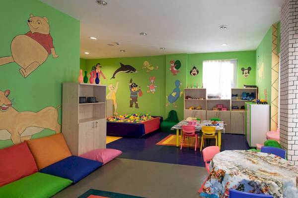 Kinderzimmer mit Ballbecken und Tischen, bunte Wände, Möbel und Spielzeug.