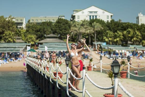 Zwei Personen am Ende eines Piers im Dobedan Beach Resort Comfort Hotel.