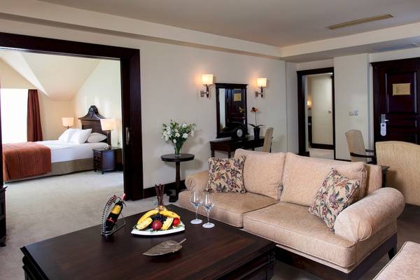 Suite Wohnbereich im Dobedan Beach Resort Comfort mit Sofa, Tisch und Früchten.