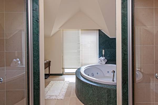 Badezimmer im Dobedan Beach Resort Comfort mit Jacuzzi und grünen Wänden.