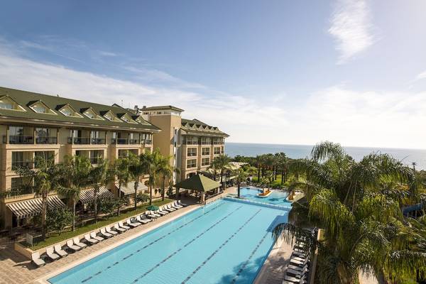 Außenansicht des Dobedan Beach Resort Comfort mit Swimmingpool und Meer im Hintergrund.