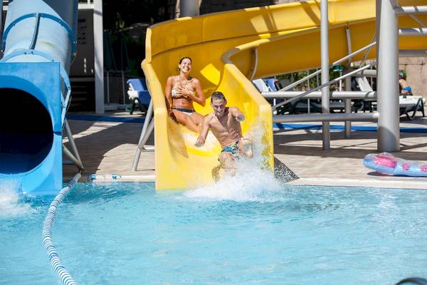 Mann und Frau rutschen im Schwimmbad des Dobedan Beach Resort Comfort