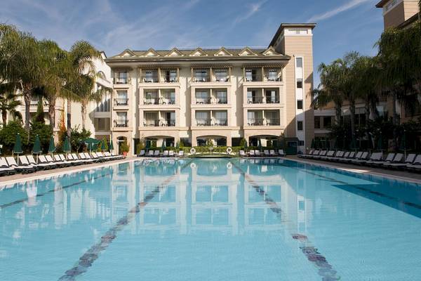 Außenbereich des Dobedan Beach Resort Comfort mit Swimmingpool und Sonnenliegen
