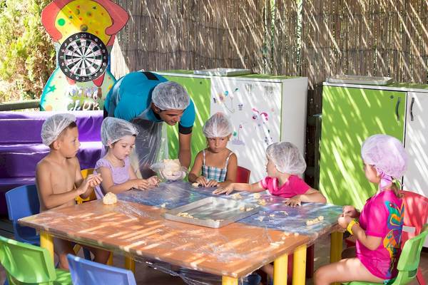 Kinder backen im Dobedan Beach Resort Comfort unter Anleitung eines Mitarbeiters.