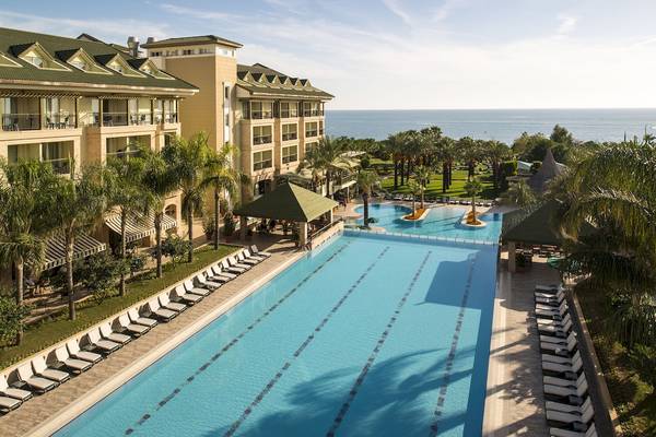 Außenpool und Loungebereich des Dobedan Beach Resort Comfort mit Blick auf das Meer.