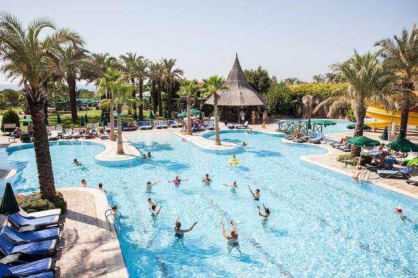 Außenbereich des Dobedan Beach Resort Comfort mit Pool, Sonnenliegen und Palmen