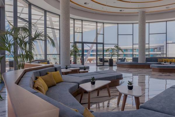 Lobbybereich des Lyttos Mare Hotels mit großen Fenstern und modernen Möbeln.