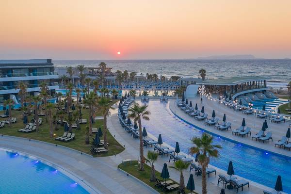 Lyttos Mare Hotel mit Sonnenuntergang am Strand und Swimmingpools.