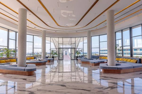 Lobby des Lyttos Mare Hotels mit Marmorboden und großen Fenstern zum Meer.