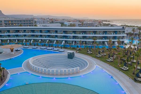 Lyttos Mare Hotel Außenbereich mit Swimmingpool und Blick auf die Stadt und Berge
