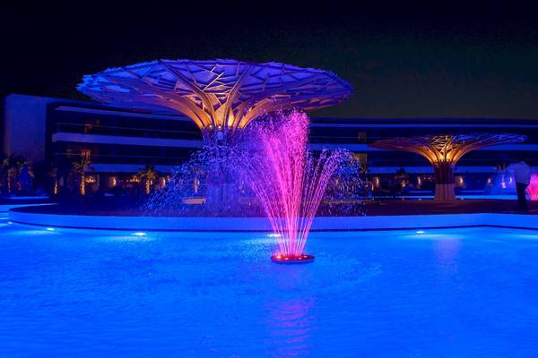 Beleuchteter Brunnen im Freien vor dem Lyttos Mare Hotel bei Nacht
