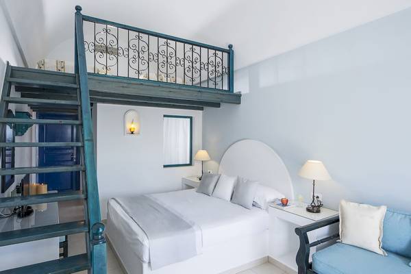 Schlafzimmer im Veggera Hotel mit Balkon, Bett, Nachttischen und Lampe.