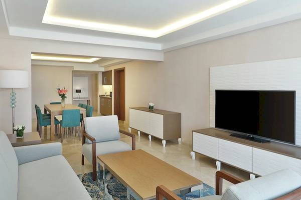 Wohnzimmer des Hilton Hurghada Plaza Hotels mit moderner Einrichtung und einem Fernseher.