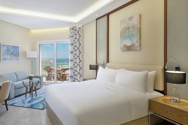 Suite-Zimmer im Hilton Hurghada Plaza mit Blick auf das Meer und moderne Einrichtung.
