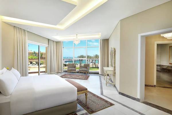 Innenansicht eines Hotelzimmers im Hilton Hurghada Plaza mit großem Bett und Ausblick auf das Meer.