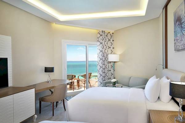 Doppelzimmer im Hilton Hurghada Plaza mit Meerblick, modernem Dekor und großen Glastüren zum Balkon.