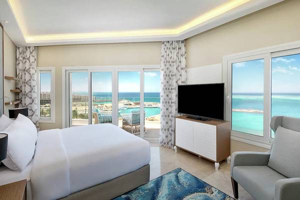 Hotelzimmer im Hilton Hurghada Plaza mit Aussicht auf den Ozean und Balkon.