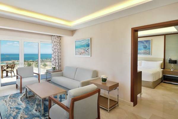Innenansicht der Suite im Hilton Hurghada Plaza Hotel mit Blick auf das Meer und Möbeln.