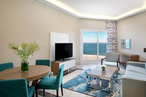 Wohnzimmer im Hilton Hurghada Plaza mit Meerblick, Fernseher, Tisch, Stühle und Sofa