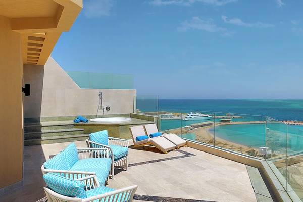 Balkon des Hilton Hurghada Plaza mit Aussicht auf das Meer und eine Sonnenterrasse.