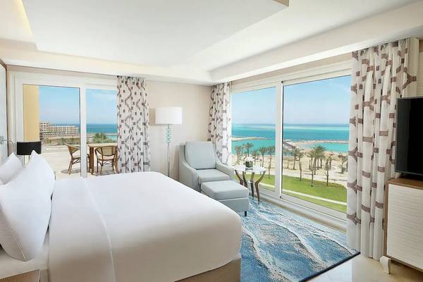 Hotelzimmer im Hilton Hurghada Plaza mit Blick auf das Meer und die Terrasse.