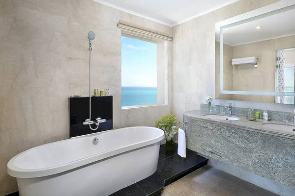 Badezimmer im Hilton Hurghada Plaza mit Blick auf das Meer, Badewanne und Doppelwaschbecken.