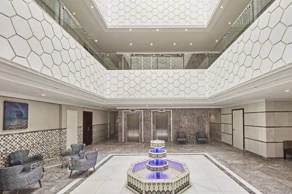 Foyer des Hilton Hurghada Plaza Hotels mit einer großen Wasserfontäne und modernen Möbeln.