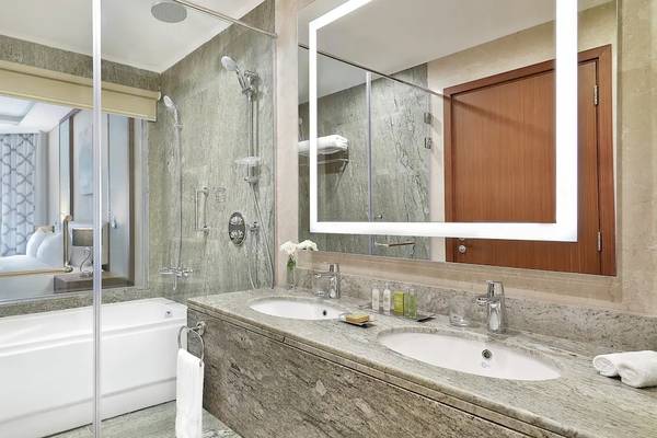 Badezimmer im Hilton Hurghada Plaza mit Badewanne, Dusche und zwei Waschbecken.