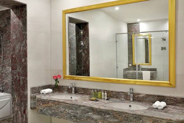 Badezimmer im Hilton Hurghada Plaza mit Badewanne, Waschbecken und Spiegel.