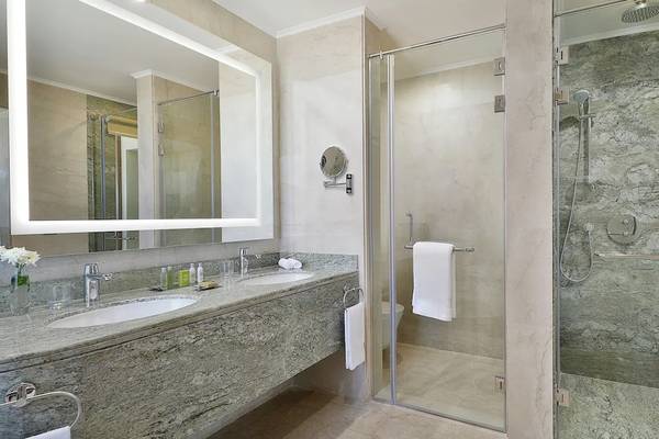 Badezimmer im Hilton Hurghada Plaza Hotel mit zwei Waschbecken und einer Duschkabine.