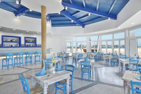 Restaurant im Hilton Hurghada Plaza Hotel mit blauen Stühlen und Tischen, Blick auf den Strand.